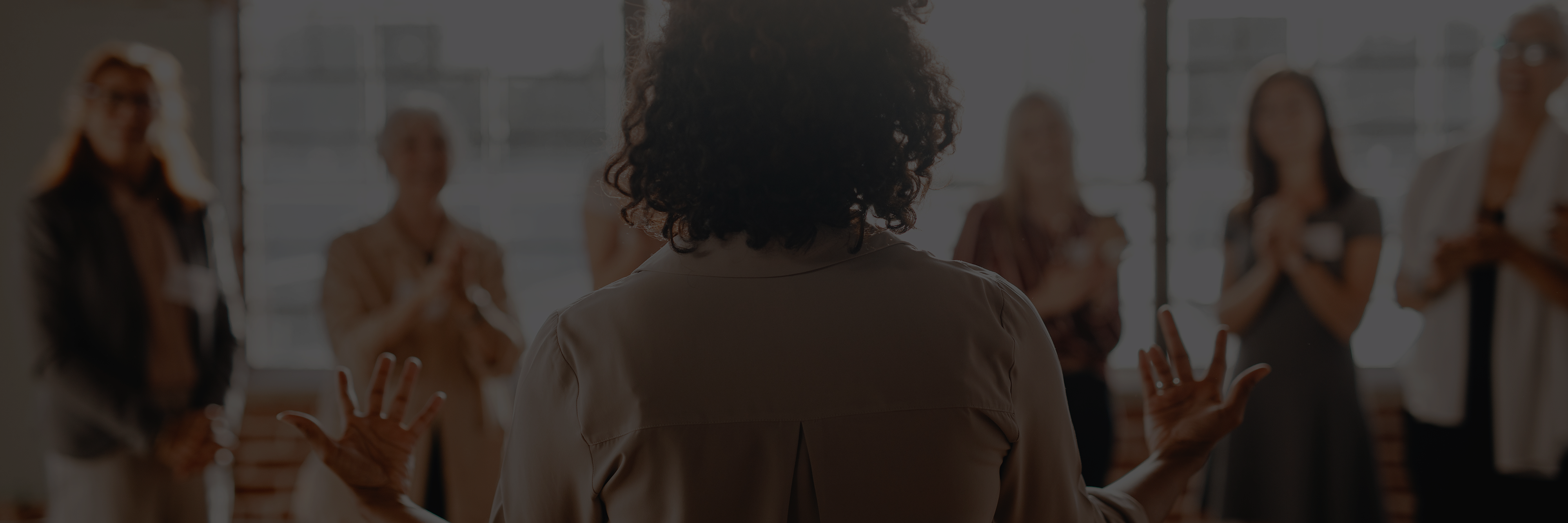 Smiling employees putting their hands together to show team spirit